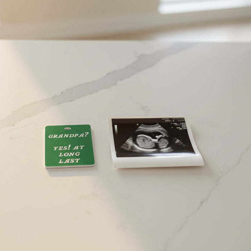 Green tag with text 'GRANDPA? YES! AT LONG LAST' on a white background