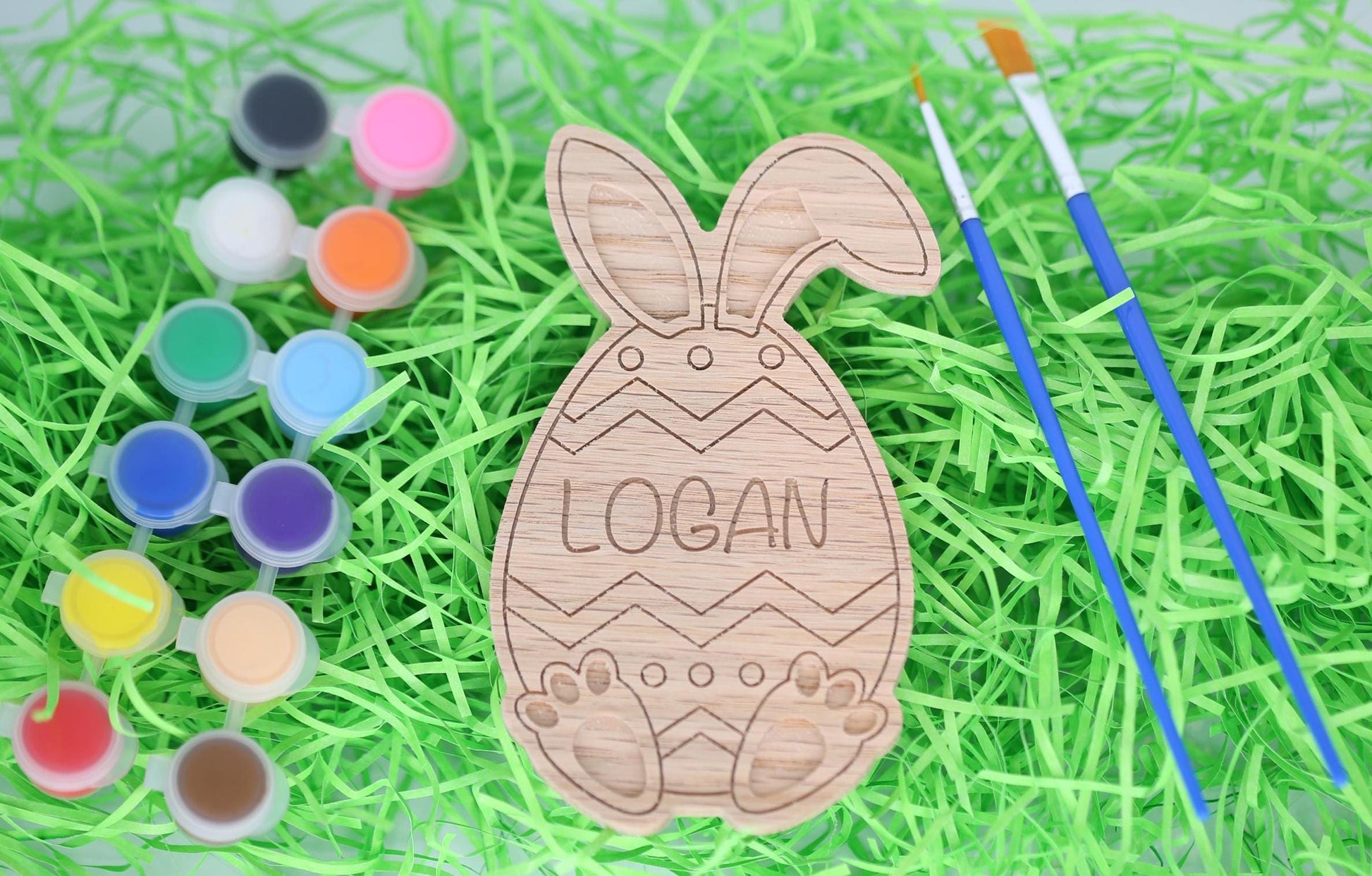 Easter egg paint craft kit with paint pots, paintbrushes and personalized Easter egg with bunny ears and bunny feet.