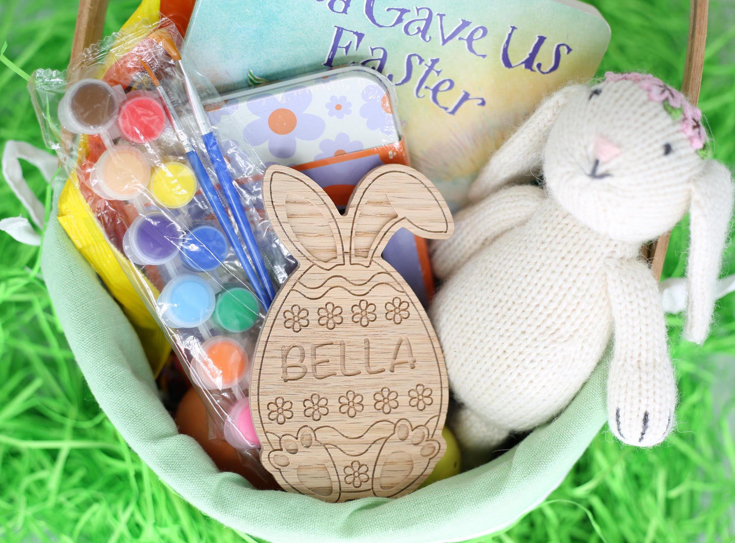 Personalized Easter egg shown in flower style with bunny ears and bunny feet inside an Easter basket.